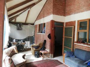 ein Wohnzimmer mit einer Couch und einer Ziegelwand in der Unterkunft Casa en el campo in Quillacollo