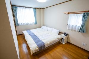 a small bedroom with a bed and two windows at No1 Private Hotel&Villa Aomoril 186平米貸切 最大12名 in Aomori
