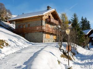 una baita di tronchi nella neve con un lampione di Chalet familial 10 pièces à Meribel, proche des pistes, avec cheminée et terrasse, 12 personnes - FR-1-180-625 a Les Allues