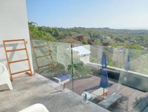 a room with a balcony with a view of the city at ELEVATE - Uluwatu, Bali in Uluwatu +17 photos