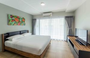 a bedroom with a bed and a large window at Chiva Bangkok Hotel in Bangkok