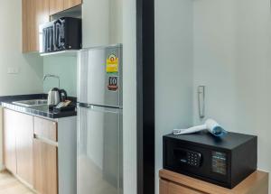 una cocina con nevera y microondas en Chiva Bangkok Hotel - SHA Plus, en Bangkok