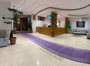a lobby with a purple carpet in the middle of a room at Mandareen Al Sharq Serviced Apartments in Az Zulfi