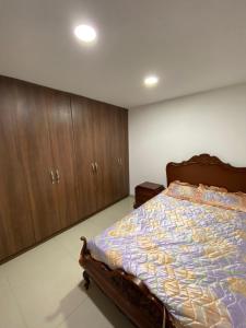 a bedroom with a bed and wooden cabinets at Espectacular casa en Manizales in Manizales