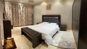 a bedroom with a large white bed and a window at Mandareen Al Sharq Serviced Apartments in Az Zulfi +28 photos