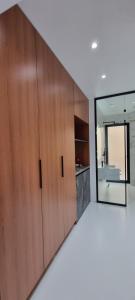 a bathroom with wooden cabinets and a mirror at Platinum INN The City in Vlorë