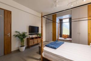 a bedroom with a large bed and a television at Saur Homestay in Jaipur
