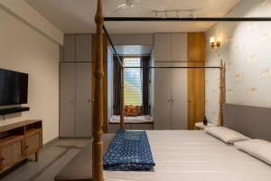 a bedroom with a canopy bed and a television at Saur Homestay in Jaipur