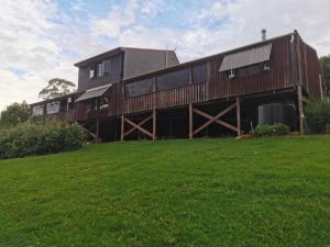 a large wooden house with a green field in front of it at Wyndover Mountain Retreat in Beechmont +53 photos