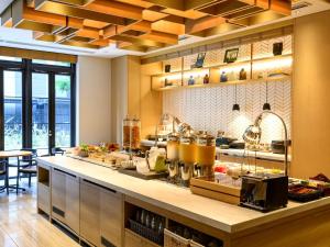 a restaurant kitchen with a counter with food at Hotel Forza Osaka Kitahama in Osaka