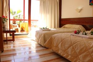 a bedroom with two beds on a wooden floor at Sidi Harazem in Fès