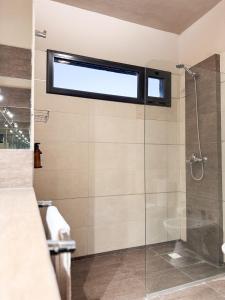 een badkamer met een glazen douche met raam bij Casa Vergara in Villa Unión