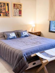 een slaapkamer met een groot bed met een blauw dekbed bij Casa Vergara in Villa Unión