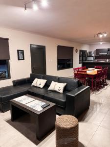 een woonkamer met een zwarte bank en een tafel bij Casa Vergara in Villa Unión