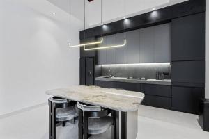 une cuisine noire et blanche avec une table et des tabourets en marbre dans l'établissement Luxurious 2 Bedroom Villa Noir, à Canggu