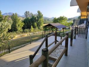 un banco de madera en un balcón con vistas en Villa el Membrillar, en Priego de Córdoba