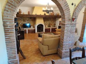 una sala de estar con un arco con sofá y chimenea en Villa el Membrillar, en Priego de Córdoba