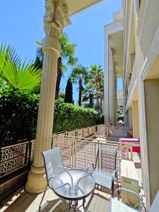 a balcony with a table and chairs and palm trees at Argisht Marina LUX Studio APT606 in Golden Sands