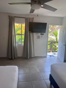 a living room with a bed and a ceiling fan at La Diosa Kali Beach Front Hotel in Holbox Island
