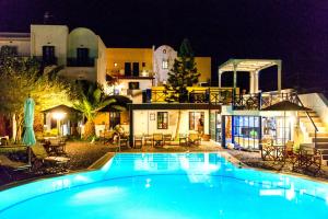 a swimming pool in front of a house at night at Kalimera Hotel in Akrotiri