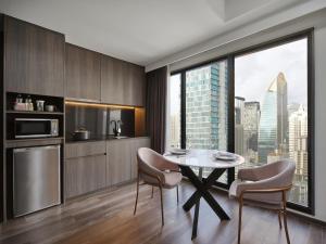 a kitchen with a table and chairs and a large window at Sindhorn Midtown Hotel Bangkok, Vignette Collection by IHG in Bangkok