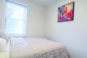 a bedroom with a bed and a painting on the wall at Cozy Home Close to Inner Harbor in Baltimore