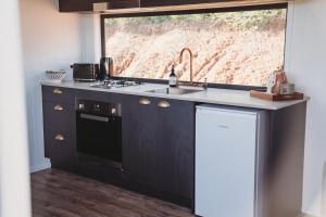 a kitchen with a sink and a window at High Valley Dawn Permaculture Farm in Yeppoon