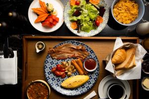 a table with a plate of food with meat and vegetables at Sindhorn Midtown Hotel Bangkok, Vignette Collection by IHG in Bangkok