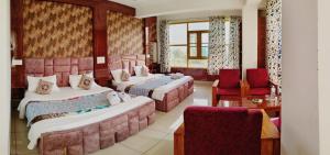 Postel nebo postele na pokoji v ubytování Gulmarg GS Residency Hotel