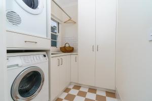 キャンベラにあるSerene 3BR Haven in Ainslie - Ideal Getaway - Hosted by Canstayの白いランドリールーム(洗濯機、乾燥機付)