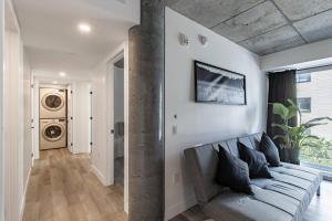 ein Wohnzimmer mit einem grauen Sofa in einem Zimmer in der Unterkunft City Center, 2 bathroom, AC, Parking, Pool in Québec