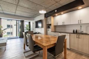 eine Küche und ein Esszimmer mit einem Holztisch und Stühlen in der Unterkunft City Center, 2 bathroom, AC, Parking, Pool in Québec