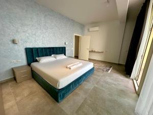 a bedroom with a large bed with a blue headboard at Queens Luxury Vila 111B in Vlorë