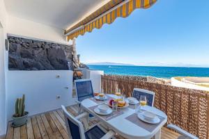 a dining room with a table and a view of the ocean at Oceanfront Oasis By Dream Homes Tenerife in Acantilado de los Gigantes