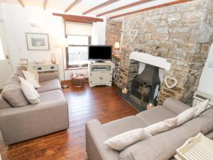 a living room with two couches and a stone fireplace at Inglenook Cottage in Haverfordwest
