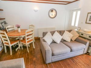 a living room with a couch and a table at Inglenook Cottage in Haverfordwest