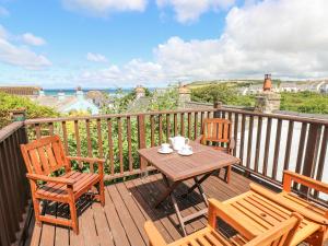 a wooden deck with a table and chairs on a balcony at Inglenook Cottage in Haverfordwest