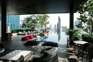 a building with a pool with tables and chairs at Sindhorn Midtown Hotel Bangkok, Vignette Collection by IHG in Bangkok