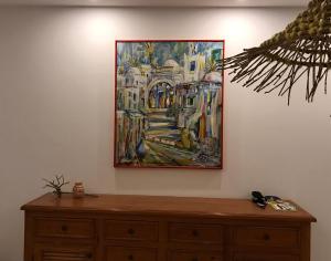 a painting hanging on a wall above a dresser at Villa pieds dans l'eau, magnifique terrasse face à la mer in Zarzis +50 photos
