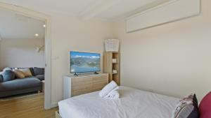 a bedroom with a bed and a flat screen tv at Alpine Heights 9 in Mount Hotham