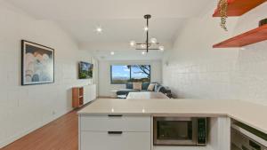 a kitchen and living room with white walls and a couch at Alpine Heights 9 in Mount Hotham