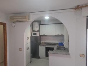 a kitchen with a sink and a stove top oven at La caleta in Oropesa del Mar