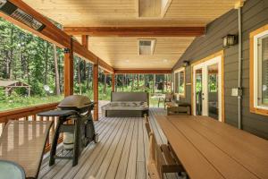 una veranda protetta con un divano su un ponte di legno di Compass Cabin by NW Comfy Cabins a Leavenworth