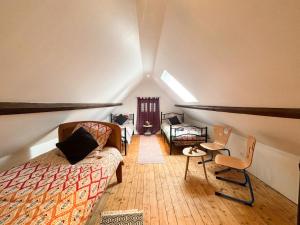 Zimmer im Dachgeschoss mit einem Bett, einem Tisch und Stühlen in der Unterkunft Maison à la campagne pour 7 pers, wifi et parking in Aube-sur-Rîle + 20 Fotos