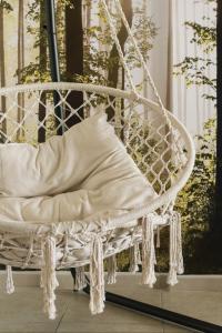 Un columpio de porche blanco con una almohada encima. en Blue & White House, en Vecindario