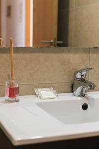 lavamanos con cepillo de dientes y espejo en Blue & White House, en Vecindario 33 fotos más