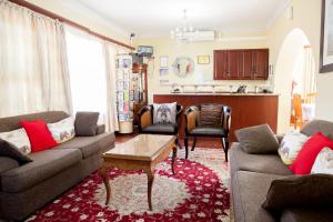 a living room with two couches and a table at Oria Guest House in Cape Town
