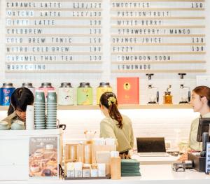 two women sitting at a counter in a coffee shop at Sindhorn Midtown Hotel Bangkok, Vignette Collection by IHG in Bangkok
