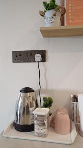 a kitchen counter with a tea kettle and a shelf at D' Tanjung Homestay-Orked in Pekan