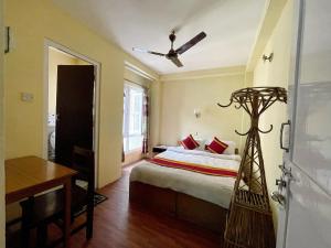 una camera da letto con un letto e un ventilatore a soffitto di Hotel New Pokhara Peace a Kathmandu